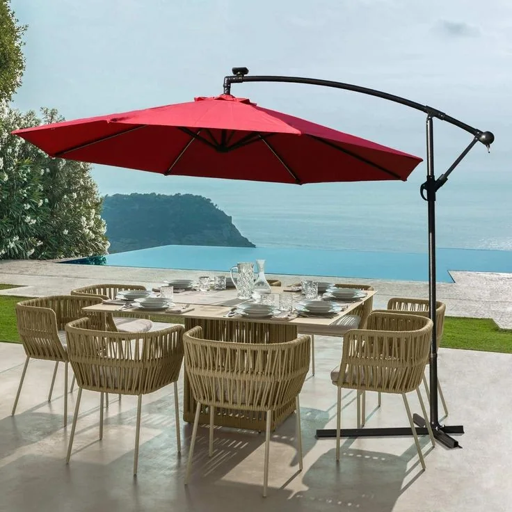 A rattan dining set under a red cantilever umbrella, from Wasi Craft's listing